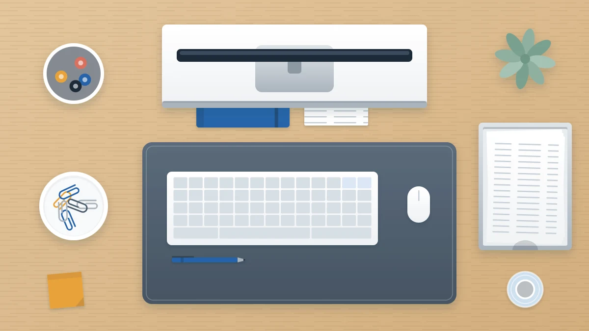 Desk from above with a keyboard, monitor on a riser, notebook tucked beneath, desk mat, pen cup, small dish and letter tray