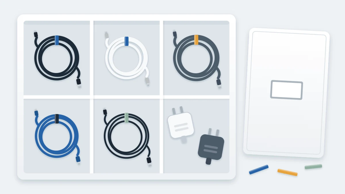 Open storage box with divided compartments, each holding one loosely coiled cable in a soft tie, and two plug adapters in a corner